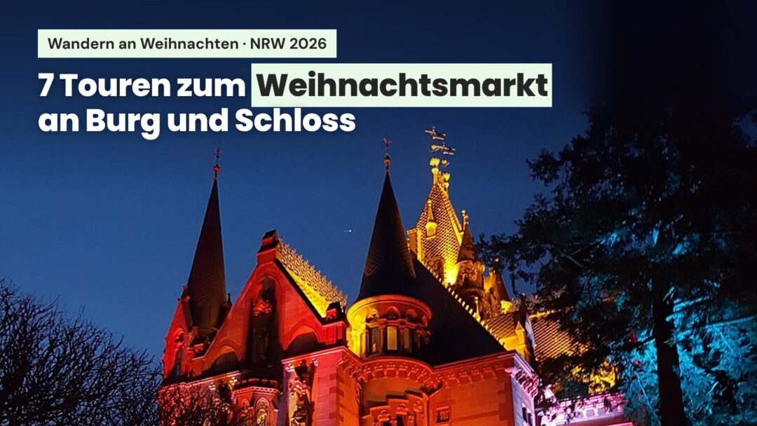 Abends bunt beleuchtetes Schloss Drachenburg im Siebengebirge mit dem Text „7 Touren zum Weihnachtsmarkt an Burg und Schloss” - Wandern an Weihnachten in NRW