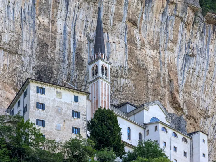 Wallfahrtskirche Madonna della Corona in der Felswand des Monte Baldo, Kirchturm und weiße Gebäude im Fels, Venetien