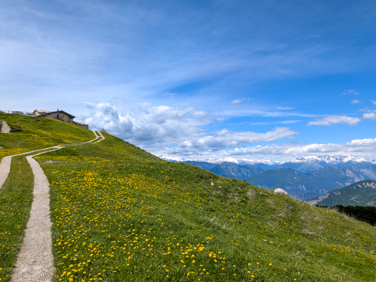 Die Almhütte Rifugio Malga Campei auf dem Hochplateau bei Brentonico, umgeben von weitem Bergpanorama – Wanderung zum Rifugio Malga Campei