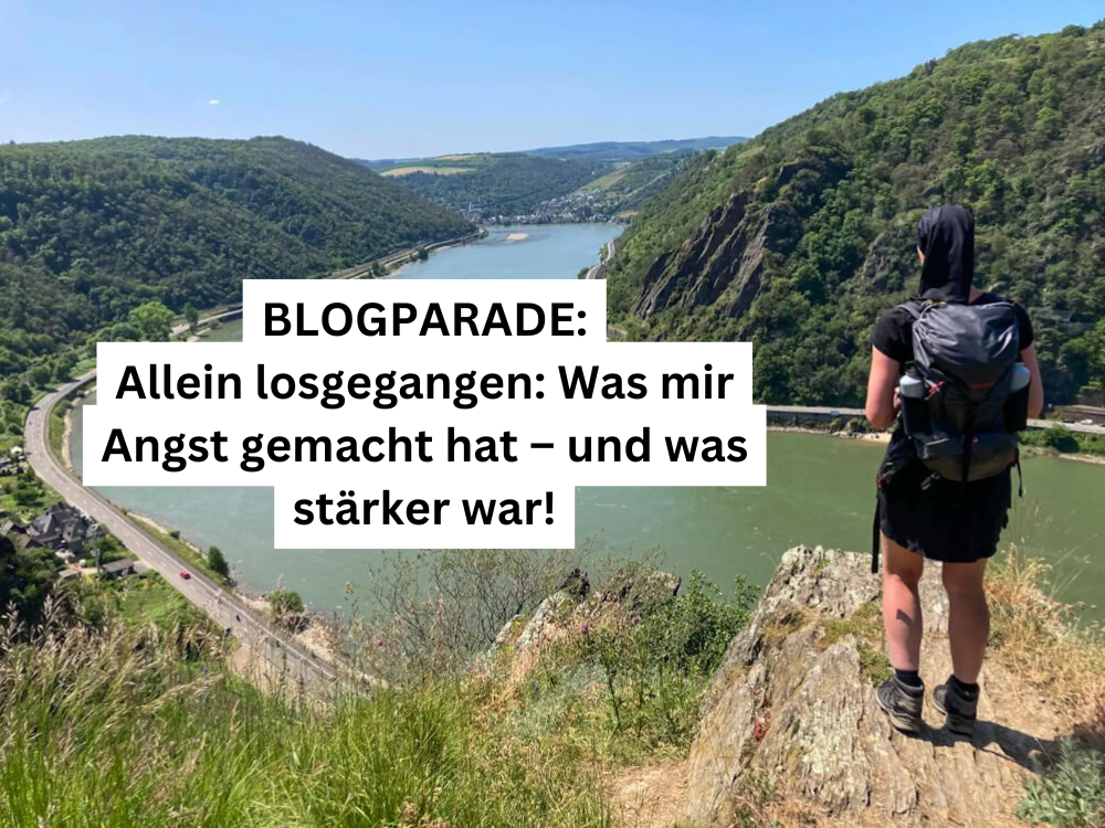 Frau mit Rucksack steht allein auf einem Felsen mit Blick auf den Rhein – Blogparade: Allein losgegangen