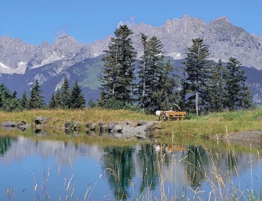 Der Wilde Kaiser spiegelt sich im Speicherteich am Koasa Trail
