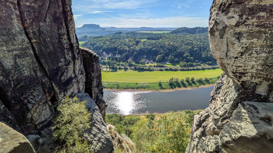 Blick durch einen Felsspalt auf die glitzernde Elbe und den Lilienstein, Malerweg Etappe 2, Bastei